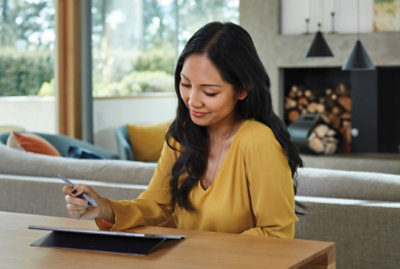 A young women in yellow sweater working on tablet