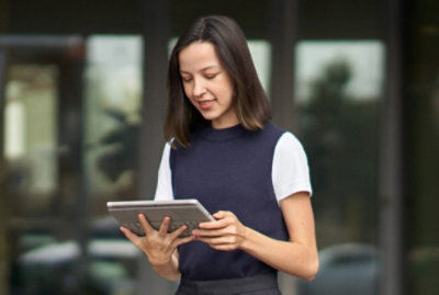 A girl in blue half sweater watching her tablet
