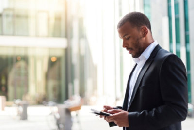 Osoba v obleku, která se dívá na telefon