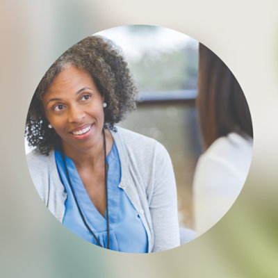 A woman smiling and looking to the side.