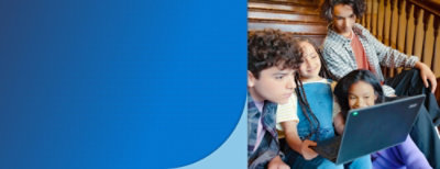 A group of kids sitting on a bench watching a laptop