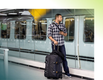 A person with luggage standing in front of metro