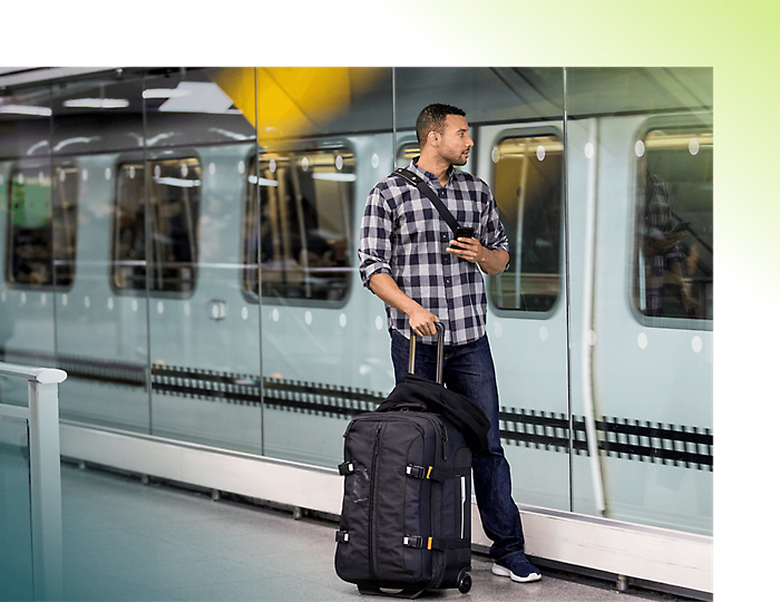 Человек с багажом, стоящий перед метро
