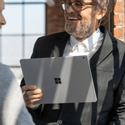A person holding Microsoft Surface Pro and talking to a person