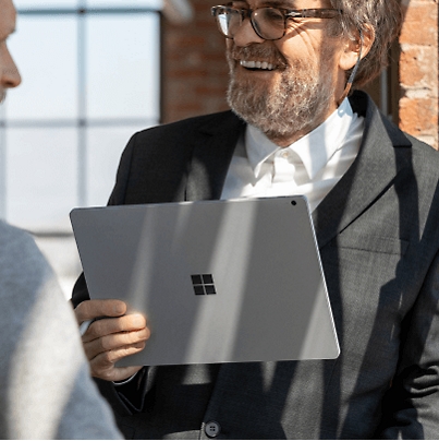 A person holding Microsoft Surface Pro and talking to a person