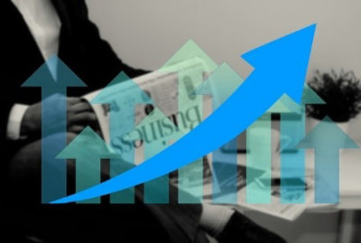 hombre de negocios leyendo el periódico. Se ve un gráfico de barras con flechas hacia arriba y una curva que marca crecimiento
