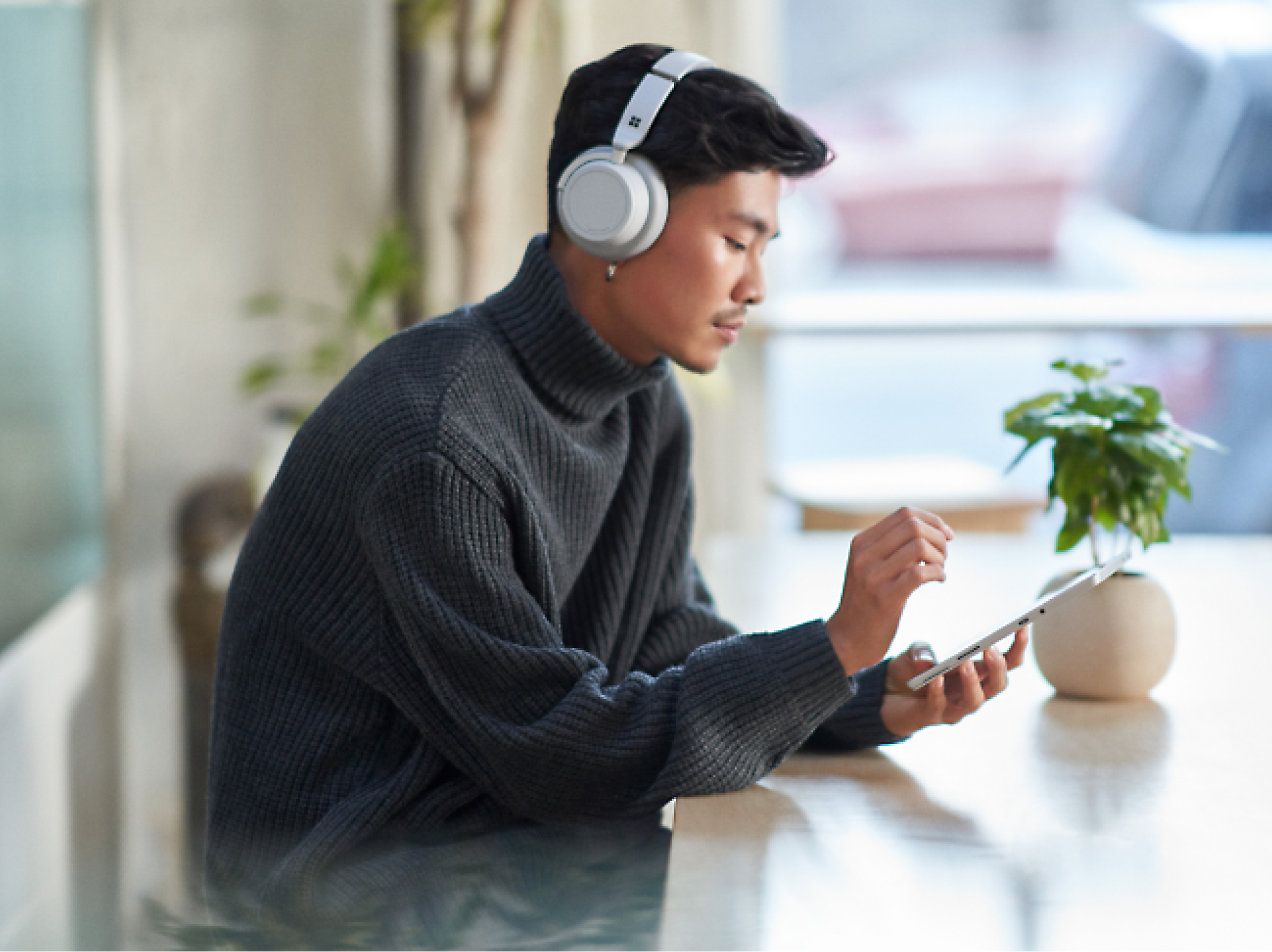A person wearing headphones and using a tablet