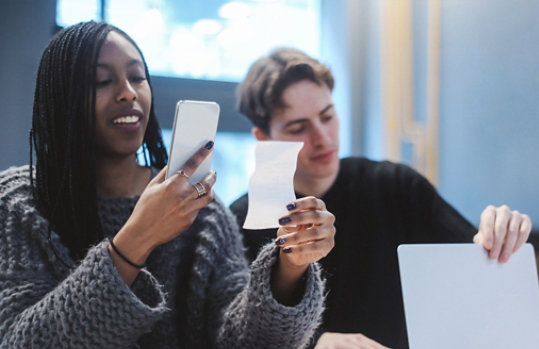 Een persoon gebruikt het touchscreen op de laptop om door foto’s te bladeren die in One Drive zijn opgeslagen.