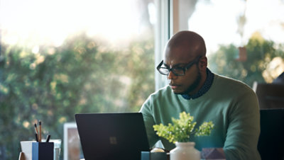 Person seated at a desk using a laptop.