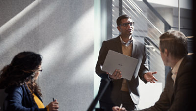 Tre personer som diskuterar i ett kontorslandskap