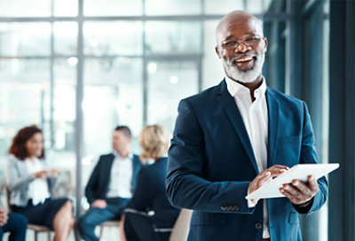 Eine Führungskraft, die lächelt und ein Tablet hält