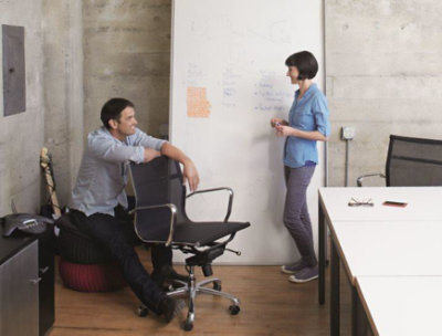 オフィス内で雑談している 2 人の人。