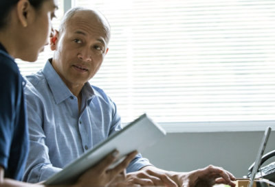 Due persone che lavorano insieme, una usa il portatile, l'altra il tablet