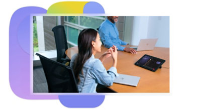 Two people in a meeting room on a Teams call using a tabletop device.