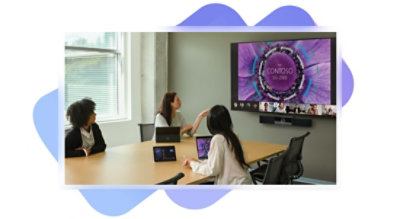 Eine Präsentation, die in einem Besprechungsraum mit persönlich anwesenden und über Teams zugeschalteten Teilnehmenden gehalten wird