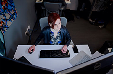 A woman sitting at a desk with a computer.