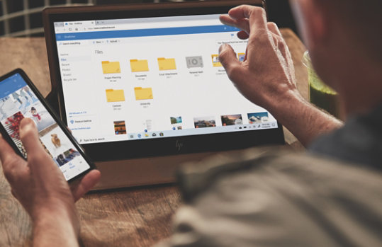 Een persoon bekijkt bestanden die zijn opgeslagen in One Drive op een mobiele telefoon en een tablet.