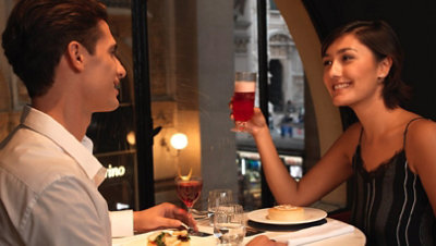 Ein Paar sitzt in einem eleganten Restaurant beim Abendessen.