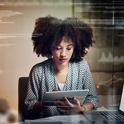 A person sitting at a desk using a tablet.
