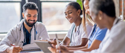 一群医疗专业人员在看一台平板电脑。