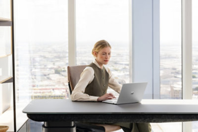 Person working at a Surface laptop at a desk.