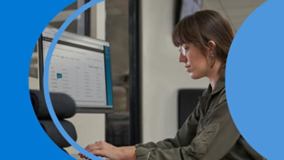 A girl sitting and looking at a computer screen