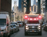 An emergency vehicle driving across a bridge 