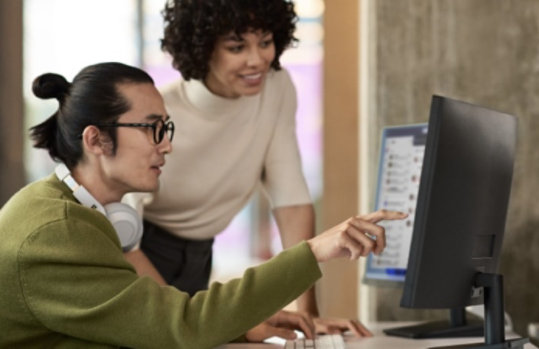 デスクトップのディスプレイを一緒に見ている 2 人のビジネス パーソン