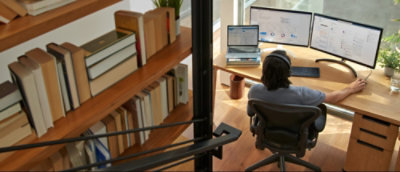 A person sitting at a desk looking at a computer