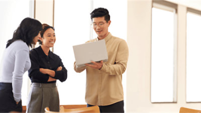 대화를 나누며 노트북을 보고 있는 세 사람