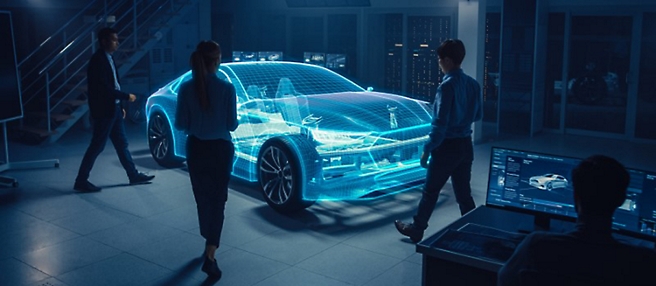 Four individuals are observing and discussing a digital 3D model of a car projected in a high-tech, dimly lit room. 