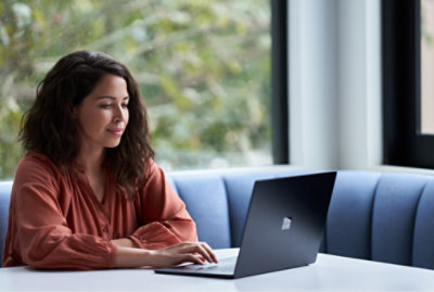 A woman sitting at a table using a laptop.