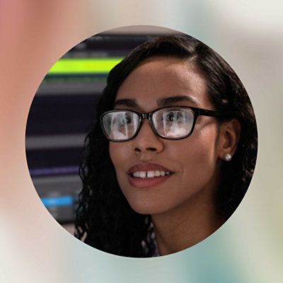 A woman wearing glasses and smiling.