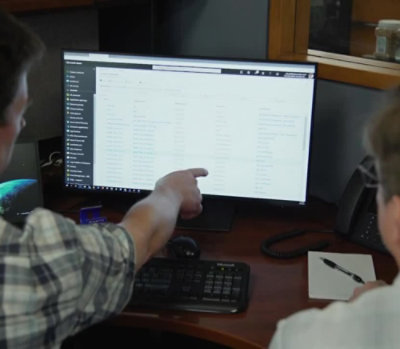 A person pointing at a computer screen.