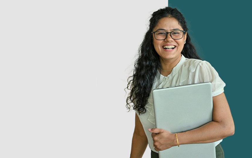 Young Public Sector female worker smiling with her laptop kept tight under her arm