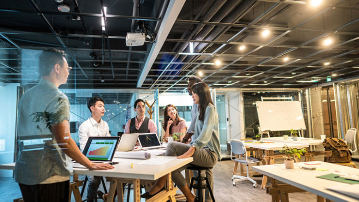 A group of young coworkers in modern work space suggest ideas for the best business strategy.