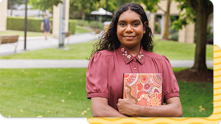 Indigenous woman holding a computer.