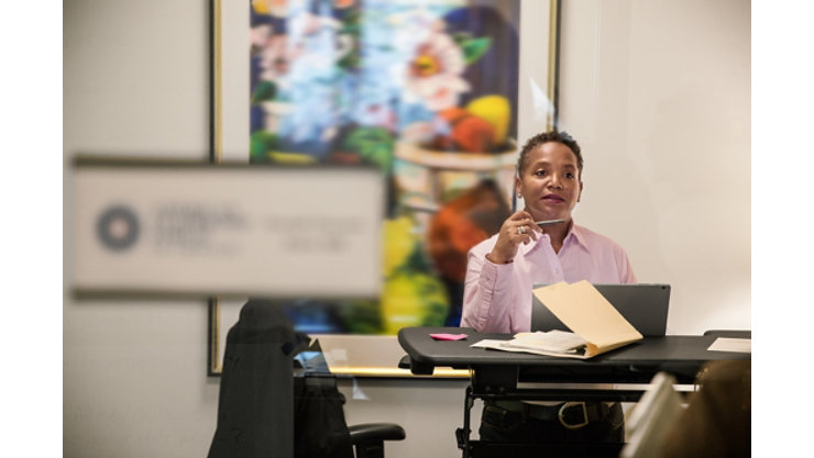 Business woman sitting at her desk with laptop placed in front of her