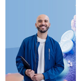 Eine Person in blauer Jacke hält ein Tablet vor einem blauen Hintergrund mit abstrakten 3D-Formen.