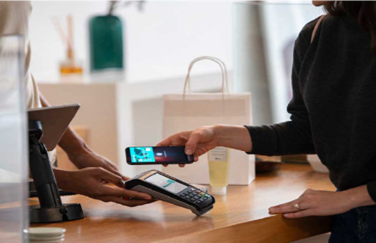 Kassentresen, an dem Kundin gerade per Handy bezahlt