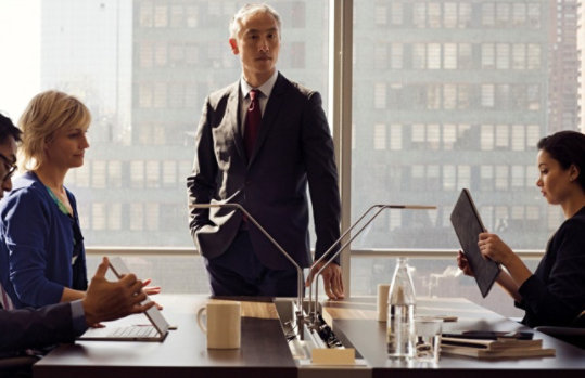 Zwei Frauen und zwei Männern in einem Meetingraum in einem Wolkenkratzer