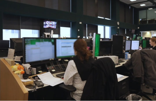 Offene Bürofläche, auf der viele Menschen am PC arbeiten