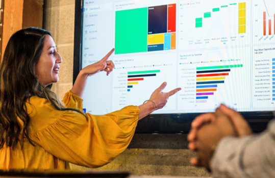 Frau, die auf einem Dynamics-Dashboard aktuelle Entwicklungen zeigt