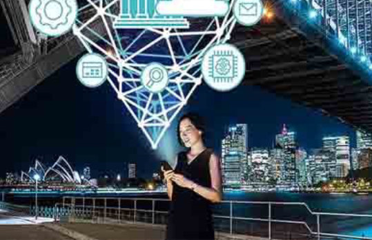 Frau vor einer Brücke bei Nacht. Über ihrem Handy erscheinen Icons für digitales Banking aus der Cloud.