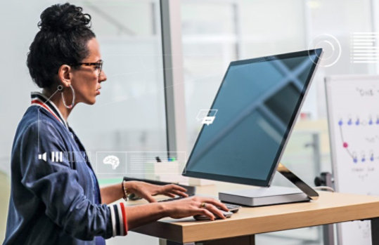 Frau, die im Stehen am Surface Studio kreativ arbeitet