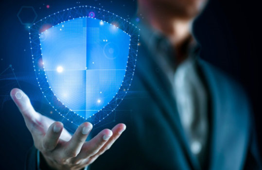 Dunkler Hintergrund, ein illustriertes, digital anmutendes Schutzschild über einer Hand.