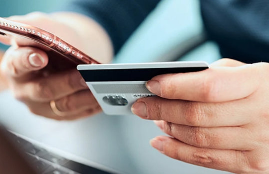 Auf dem Bild sind 2 Hände abgebildet welche jeweils eine Kreditkarte und ein Smartphone halten.