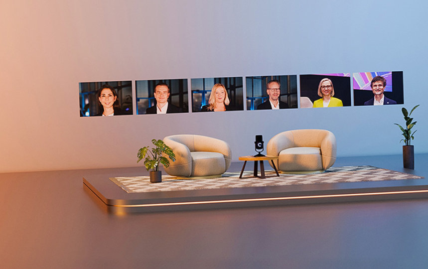 Virtuelle Bühne mit Sesseln, Mikrofon, Pflanzen und Bildschirmen, die Personen zeigen.