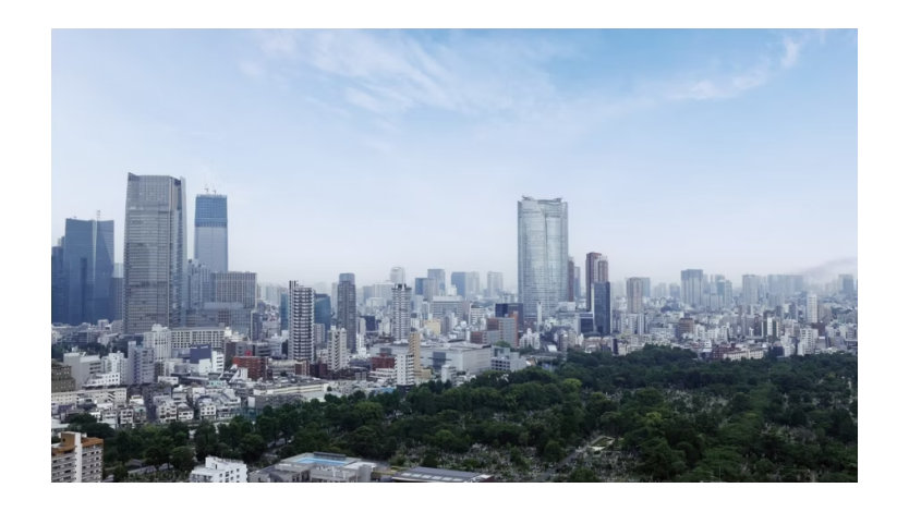  高層ビル群と緑豊かな森が広がる都市の眺め。