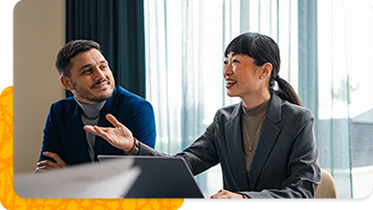 Two business professionals discuss work in an office.